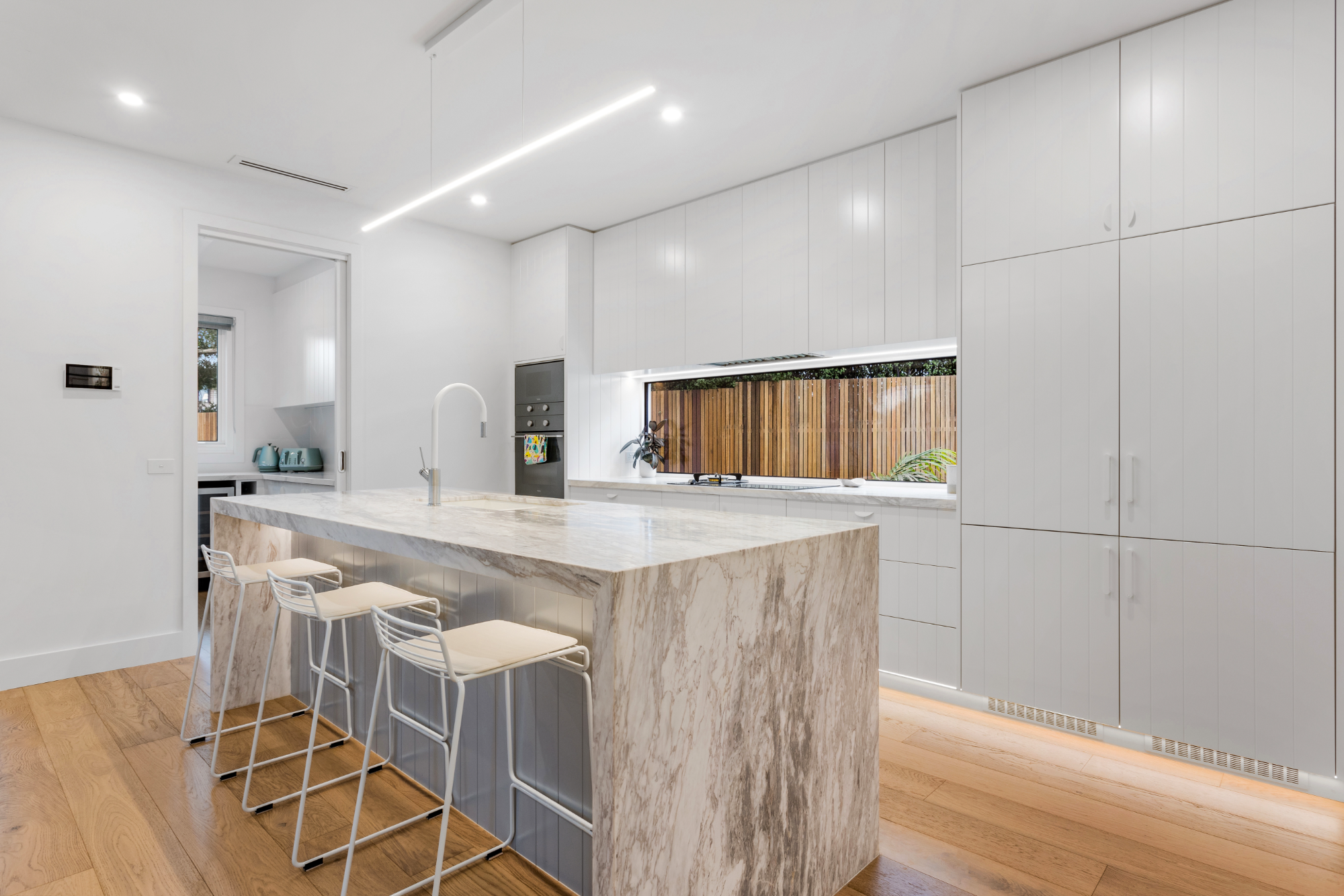 Marble waterfall island kitchen with bar seating