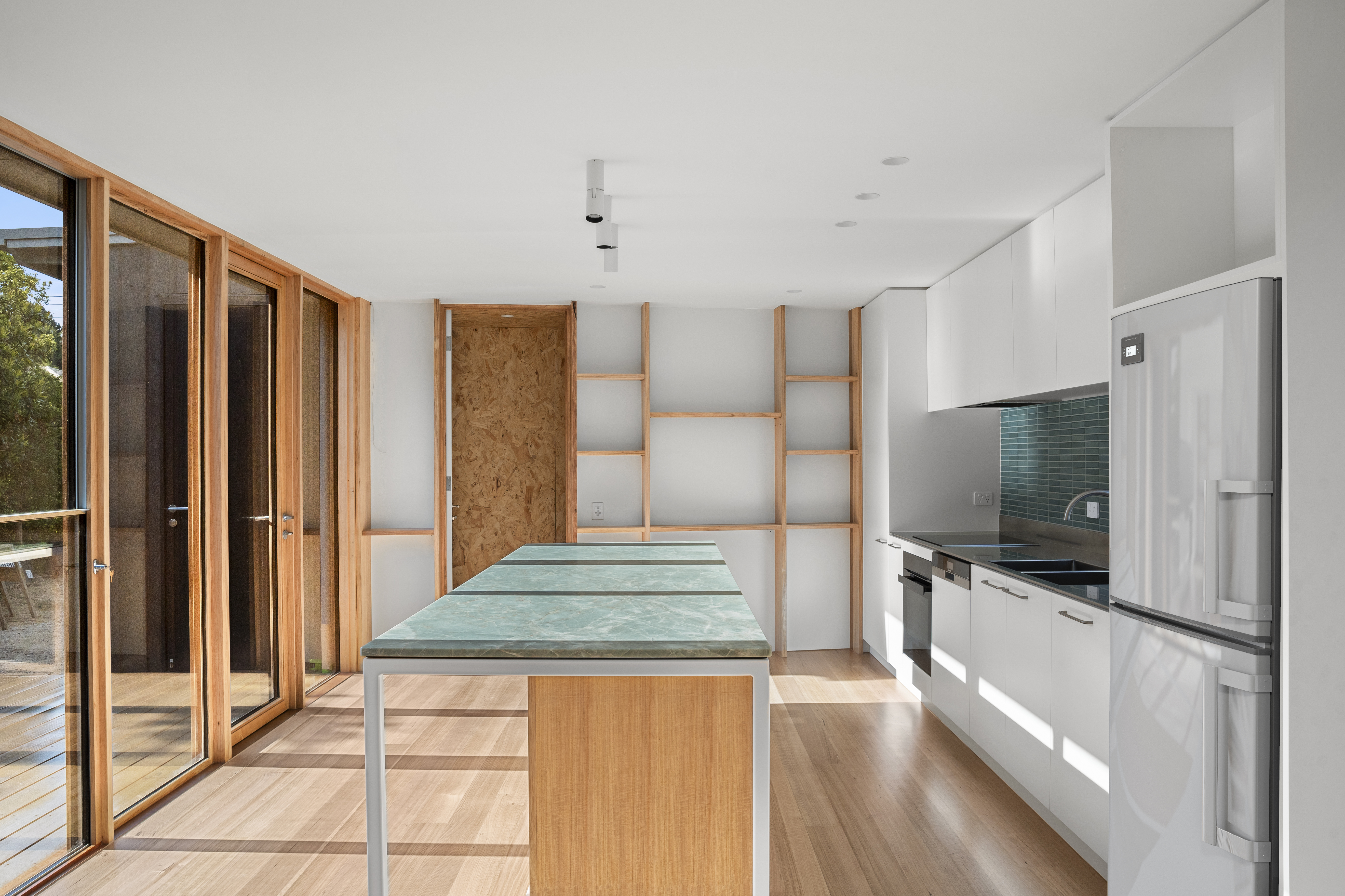 Kitchen with green marble island and timber joinery